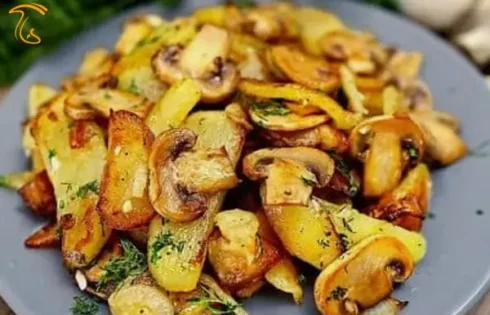 عکسی از یک بشقاب سیب زمینی با قارچ است. با توجه کردن به عکس می‌توان طرز تهیه خوراک سیب زمینی و قارچ را تا حدودی متوجه شد.